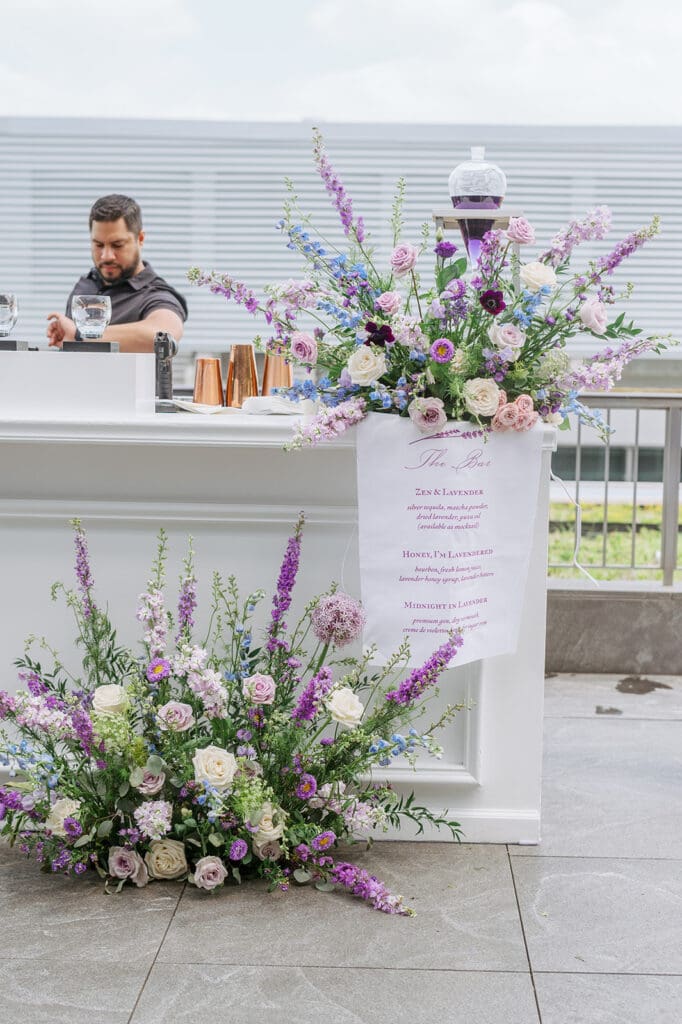 Decorated bar with florals and a Custom Linen Bar Sign used in a Whimsical Garden Rooftop Party 