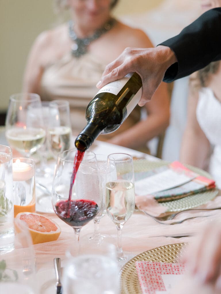 hand pouring wine with a colorful wedding tablescape in 2941 restaurant viginia