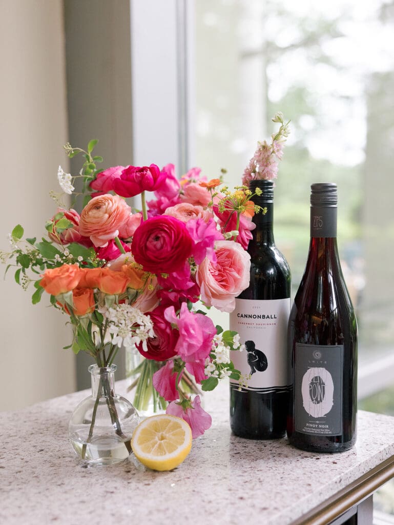 colorful pink and orange florals next to a wine bottle for this northern virginia wedding