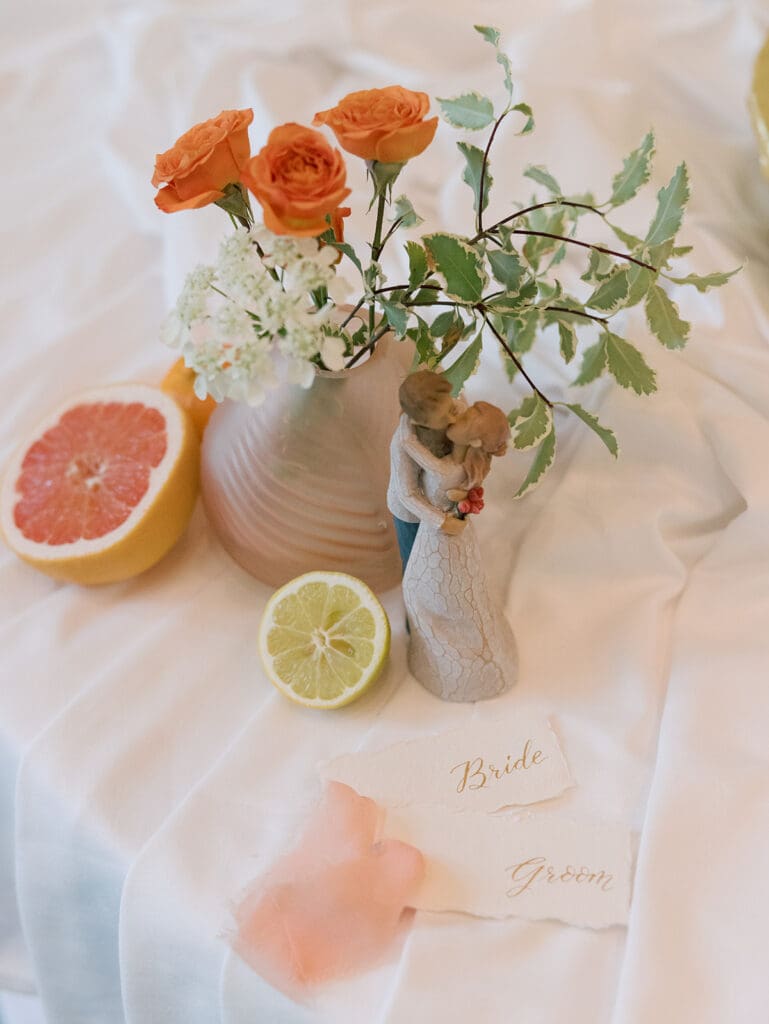 bride and groom place cards written in calligraphy for a virginia wedding laid out with some citrus fruits and flowers