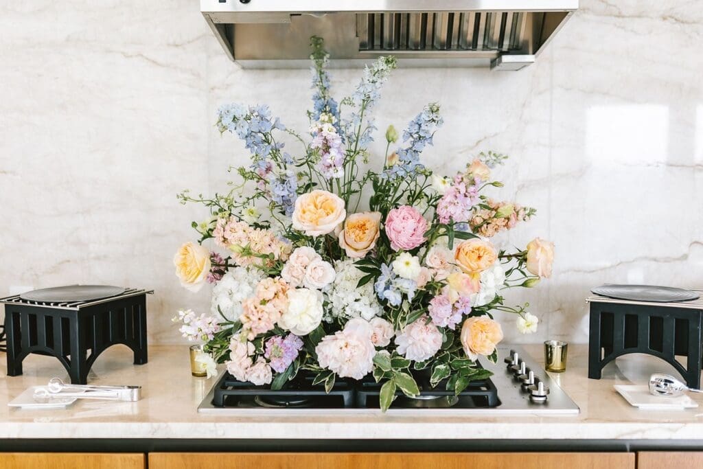 organic pastel florals pink, orange, blue, white on a clean marble surface