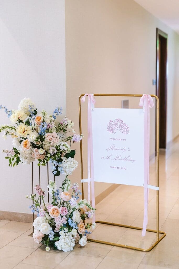 custom event signage at the four seasons baltimore displayed in hallway with tower of pastel flowers