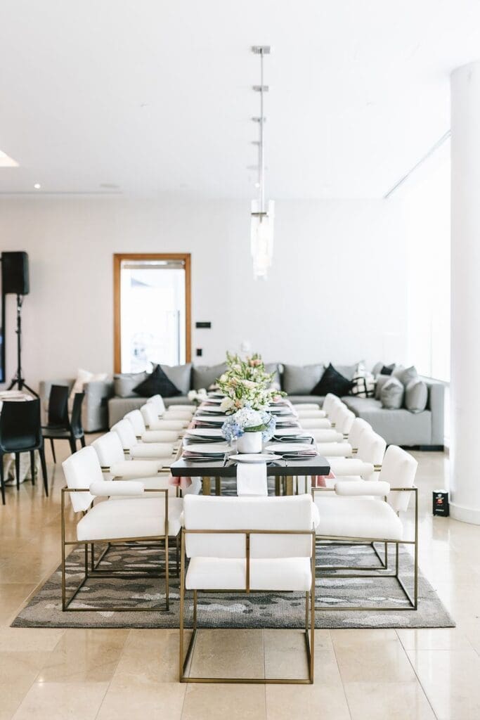 open space entertainment lounge at the four seasons baltimore residences with white chairs and gray couch