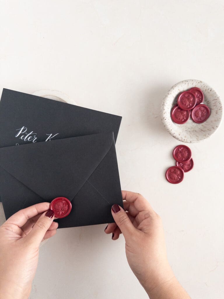 assembling wax seals on wedding invitation envelopes