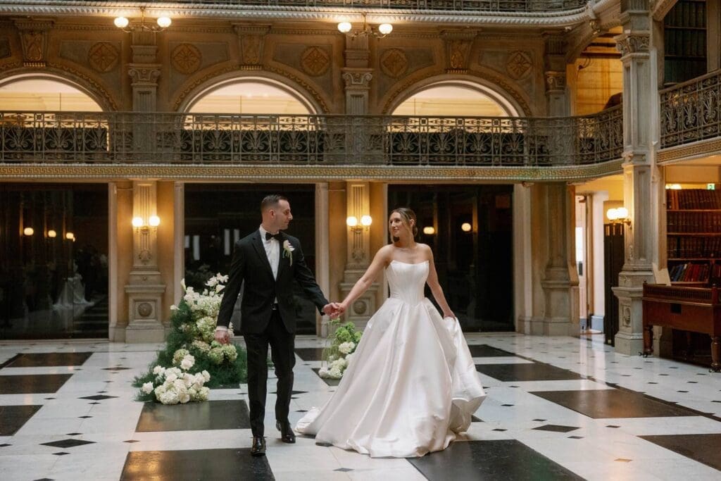 george peabody library baltimore wedding, bride and groom holding hands in a historical venue